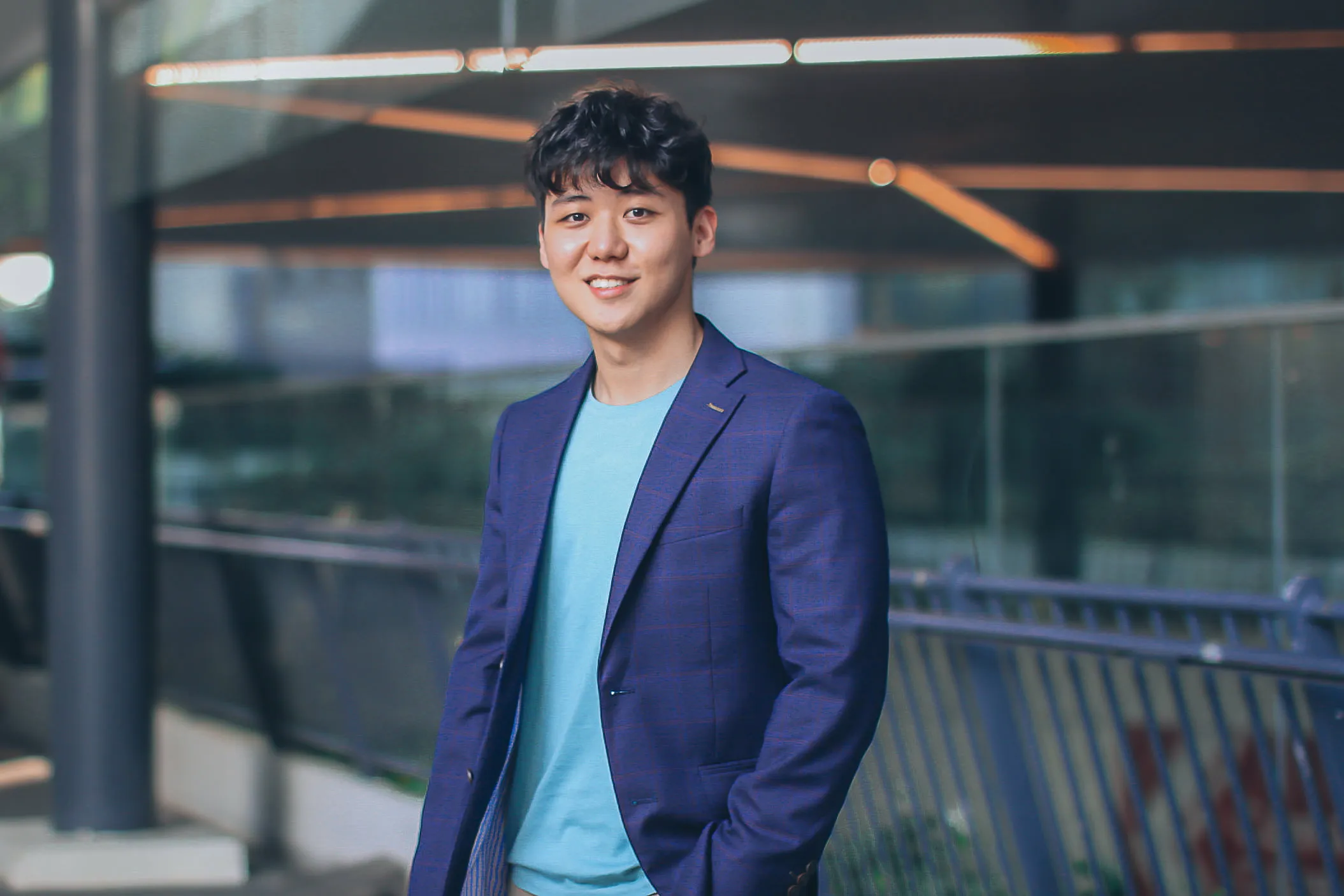 Eugene Cheng in a navy blazer at an architectural glass building
