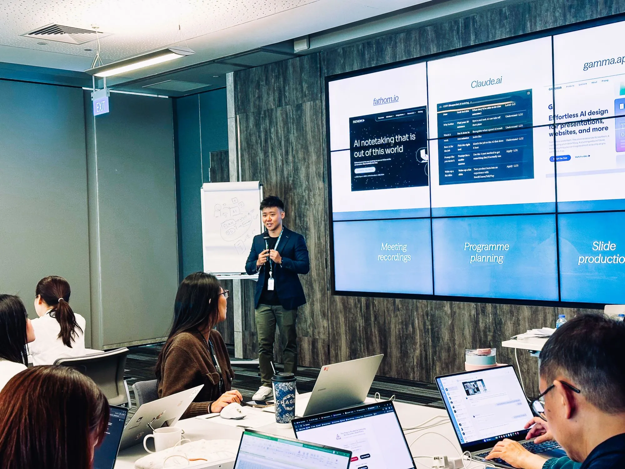 Eugene Cheng teaching an AI tools workshop, with Fathom, Claude and Gamma on the screens behind him